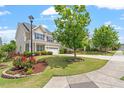 Well-manicured lawn and front yard with mature tree and tasteful landscaping in front of a charming home at 4509 Joe Cotton Dr, Knightdale, NC 27545