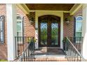 Elegant front entrance features double doors with wrought iron accents and sidelight windows at 5025 Martin Farm Rd, Raleigh, NC 27613