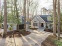 Charming home with gray siding, a well-manicured front lawn, and a paved driveway leading to a detached garage at 7116 Asheway Dr, Holly Springs, NC 27540