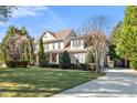 Beautifully landscaped home featuring a manicured lawn, driveway, and lush greenery for privacy at 7516 Orchard Crest Ct, Apex, NC 27539