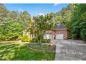 Brick home featuring an attached garage, driveway and well-maintained landscaping, enhancing the property's appeal at 10011 Hammock Bnd, Chapel Hill, NC 27517