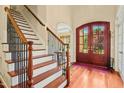 Elegant foyer with hardwood floors, staircase, and arched doorway, showcasing classic architectural details at 10011 Hammock Bnd, Chapel Hill, NC 27517