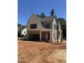 New construction exterior featuring white brick, gray siding, an attached two-car garage, and a modern architectural style at 1002 Canterbury Rd, Raleigh, NC 27607