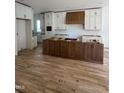 Spacious kitchen with white cabinetry, a dark wood island, and hardwood flooring at 1002 Canterbury Rd, Raleigh, NC 27607