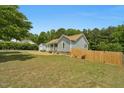 Home featuring light grey siding, a welcoming porch, detached garage, and fenced in yard at 109 N Valley Dr, Louisburg, NC 27549