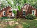 Charming brown two-story home featuring a quaint front porch entrance and green lawn at 112 Cameron Ct, Cary, NC 27511
