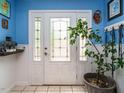 Elegant front door with frosted glass and decorative sidelights set against bright blue walls at 112 Cameron Ct, Cary, NC 27511