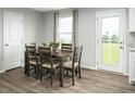 Dining area features a wooden table with seating for six, wood flooring and a door to the outside at 117 N Coral Bells Way, Four Oaks, NC 27524