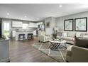 Open-concept living room with modern furniture, and an eat-in kitchen with an island and stainless appliances at 117 N Coral Bells Way, Four Oaks, NC 27524