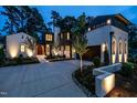 Beautiful two-story home with a painted brick exterior, dark trim, elegant lighting and a circular driveway at 1222 Duplin Rd, Raleigh, NC 27607