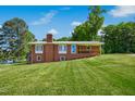 Charming brick home showcasing a well-manicured lawn and classic architectural details with a glimpse of the nearby lake at 1415 Clearwater Dr, Sanford, NC 27330