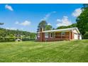 Scenic exterior shot highlighting the brick house, waterfront access, and well-kept lawn in a tranquil lakeside setting at 1415 Clearwater Dr, Sanford, NC 27330