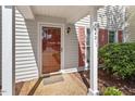 Close-up of townhome front door with storm door and brick-lined walkway at 1442 Aversboro Rd # 7, Garner, NC 27529