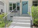 Close up of a light blue front door with painted brick steps and black railing at 1521 N Duke St, Durham, NC 27701