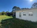 View of the grassy backyard with a white building featuring a door and several windows at 167 Chic Ennis Rd, Coats, NC 27521