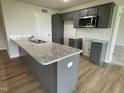 A bright kitchen features gray cabinets, granite countertops, and modern finishes at 167 Lotus Ave, Smithfield, NC 27577