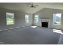 Spacious living room with large windows and a cozy fireplace, perfect for relaxing and entertaining at 199 Lotus Ave, Smithfield, NC 27577