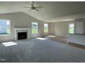 Inviting living room featuring a fireplace, vaulted ceiling, and smooth transition to the kitchen at 199 Lotus Ave, Smithfield, NC 27577