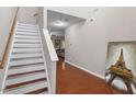Entryway featuring hardwood floors, a staircase, and neutral wall paint at 208 Station Dr, Morrisville, NC 27560