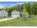Beautiful one-level home featuring an attached garage, green lawn, and serene landscaping at 230 Forest Meadow Ln, Franklinton, NC 27525