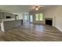 Open-concept living area featuring wood floors, a fireplace, and natural light at 253 Busterfield Ct, Benson, NC 27504