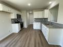 Modern kitchen with white cabinets, stainless steel appliances and beautiful wood-look flooring at 253 Lotus Ave, Smithfield, NC 27577