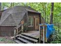 View of geodesic home with wood-shingled roof and covered porch, showing the front door at 3312 Hawk Ridge Rd, Chapel Hill, NC 27516