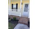 Close-up of the front porch featuring brick steps and a white railing, offering a cozy entrance at 3609 Cold Harbour Dr, Raleigh, NC 27610