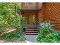 Inviting front entrance with a wood door, stairs, and surrounded by lush greenery at 3622 Moonlight Dr, Chapel Hill, NC 27516