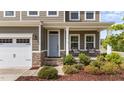 Charming front porch with stone accents, gray siding, and lush landscaping at 3700 Horton Hill Dr, New Hill, NC 27562
