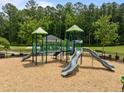 Outdoor playground with slides, a climbing structure, and a wood chip ground covering at 3700 Horton Hill Dr, New Hill, NC 27562