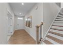 Bright foyer with hardwood floors, staircase, and modern artwork at 3700 Horton Hill Dr, New Hill, NC 27562
