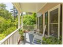 Charming front porch featuring rocking chairs, plants, and serene views of the surrounding greenery at 401 Robert Hunt Dr, Carrboro, NC 27510