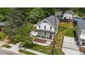 An aerial view of a two-story white home featuring a metal roof, front porch, and landscaped front yard at 412 W Stallings St, Clayton, NC 27520