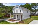 Side view of a two-story home featuring a covered porch, landscaped front yard, and a metal roof at 412 W Stallings St, Clayton, NC 27520