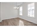 Bright dining room features hardwood floors, large windows providing ample light, and a contemporary chandelier at 416 Longleaf Glen Ln, Zebulon, NC 27597