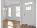 Bright entryway with hardwood floors, a white front door with glass accents, and large windows offering natural light at 416 Longleaf Glen Ln, Zebulon, NC 27597