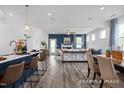 Stylish living space featuring an open layout with kitchen island seating, fireplace, and plenty of natural light at 420 Longleaf Glen Ln, Zebulon, NC 27597