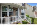 Inviting covered front porch with white railings and brick accents at 513 Heswall Ct, Rolesville, NC 27571