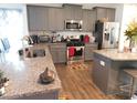 Modern kitchen featuring stainless steel appliances, granite countertops, and breakfast bar seating at 633 Longstanton Ave, Zebulon, NC 27597