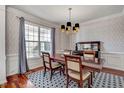 Inviting dining room with a stylish chandelier, large window, and classic wallpaper at 704 Valleywater St, Fuquay Varina, NC 27526