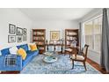 Cozy living room with a blue couch, bright blue rug, and a large window, creating a relaxing atmosphere at 704 Valleywater St, Fuquay Varina, NC 27526