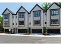 Modern townhome exterior showcasing black framed windows, garage doors, and a well-maintained landscape at 810 Maple Berry Ln # 104, Raleigh, NC 27607