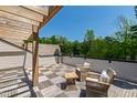 Outdoor patio area with two chairs, a small table, wooden pergola, and serene surrounding trees at 810 Maple Berry Ln # 104, Raleigh, NC 27607