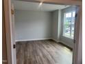 Bright, empty bedroom with wood flooring, large window, and neutral paint at 95 Black Walnut Dr # 191, Garner, NC 27529