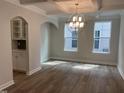 Open dining room with wood floors, coffered ceiling, modern chandelier, and built-in cabinets at 95 Black Walnut Dr # 191, Garner, NC 27529