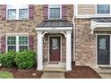 Inviting entrance with a decorative front door and manicured landscaping around the column-supported porch at 1001 Tender Dr, Apex, NC 27502