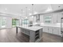 Bright kitchen featuring a large center island, white cabinets, and stainless steel appliances at 1009 Middleground Cir, Durham, NC 27713