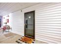 Apartment door with a storm door, welcome mat, and some patio furniture at 107 Sturbridge Dr, Clayton, NC 27520