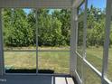 Relaxing screened porch providing a serene view of the lush backyard at 1080 River Glade Ct # 17, Graham, NC 27253
